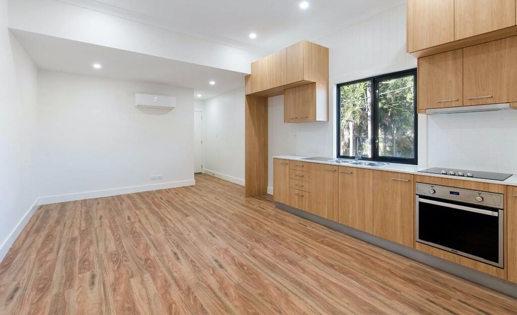cocina vacía con piso y mueble para fregadero de madera