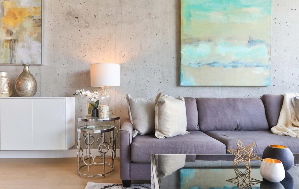 sala con cuadro y mesas de centro metálicas y sillón de terciopelo con cojín