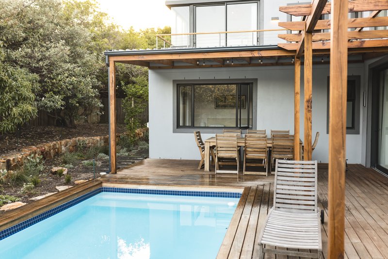 casa de dos pisos, fachada trasera color blanco con teja y terraza con alberca